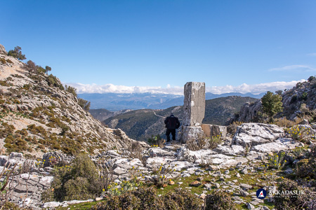 Visitor beside the weathered watchtower remains on the Sidyma acropolis