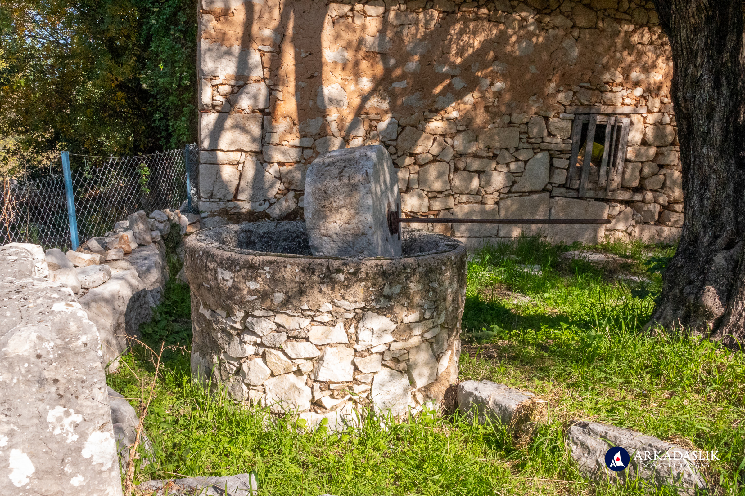 Ancient olive press in the garden of a modern home in Dodurga