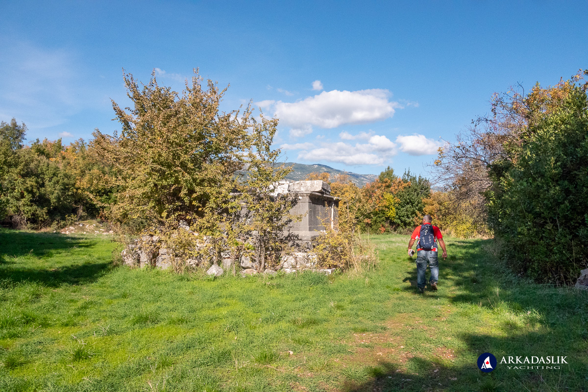 Man walking beside massive monumental tomb.