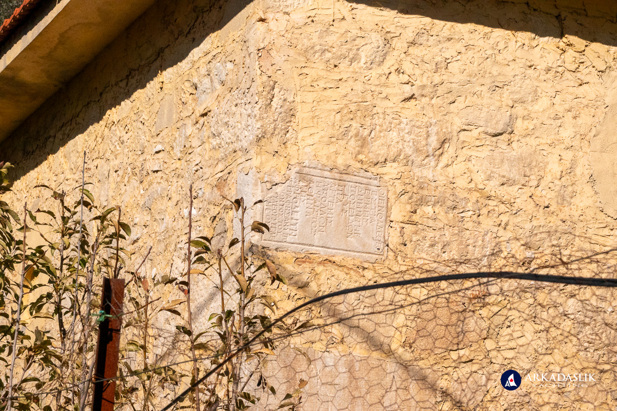 Exterior mosque wall showing reused inscribed stones.
